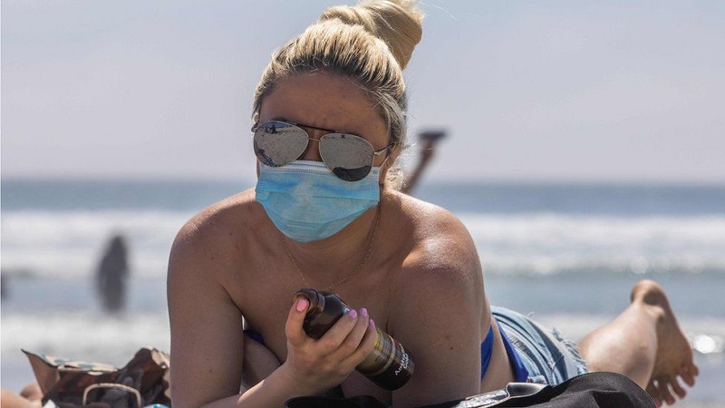 Mulher usando máscara em praia